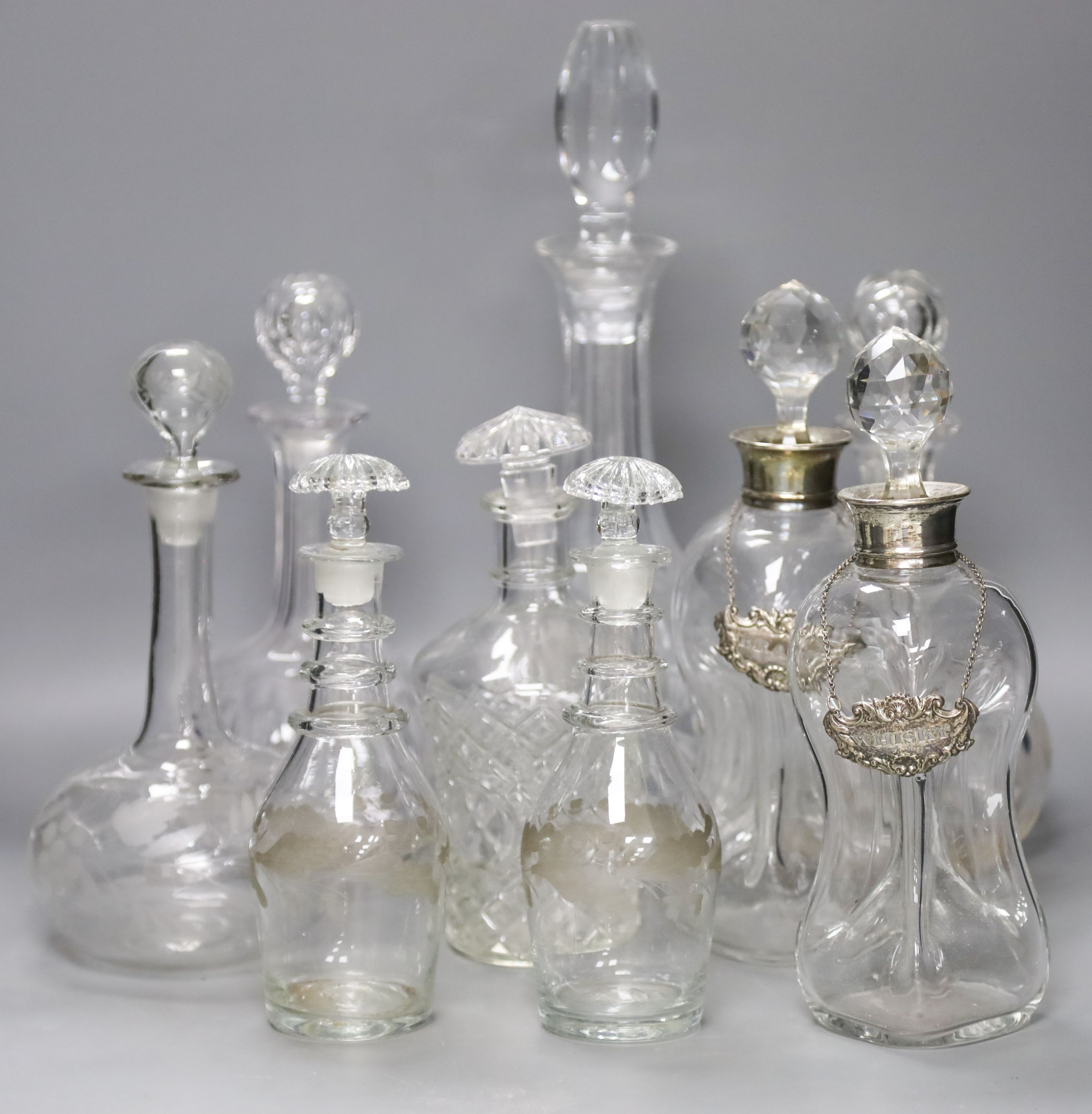 A pair of Regency small cut glass decanters, a pair of silver-mounted 'dimple' decanters, another pair of decanters and two other decanters.